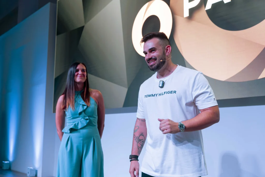 Foto de Fabio Serna en un evento presencial de la formacion partner 360. Al fonde está su pareja.